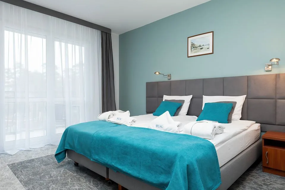 Pokój hotelowy z łóżkiem i tapicerowanym zagłówkiem